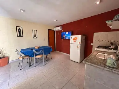 a kitchen with a table with chairs and a refrigerator at Lo De ADRI in Villa Carlos Paz