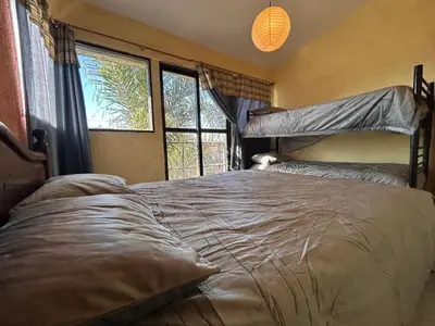 a bedroom with a bunk bed and two windows at Lo De ADRI in Villa Carlos Paz