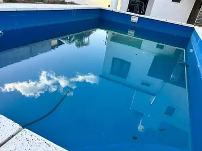 a blue swimming pool with the sky in the water at Lo De ADRI in Villa Carlos Paz