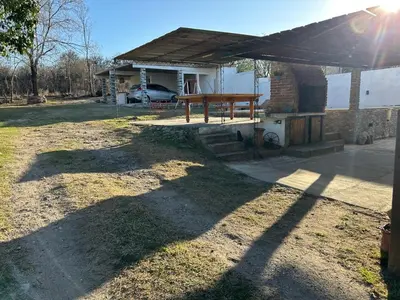 a house with a picnic table in the yard at Lo De ADRI in Villa Carlos Paz