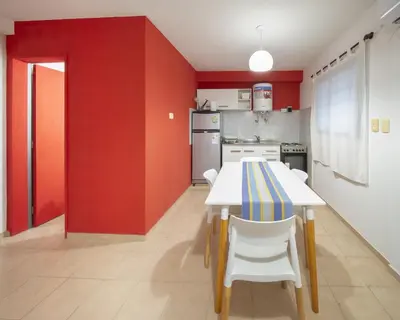 a kitchen with red walls and a table and chairs at Hermoso Departamento Planta Baja in Cordoba
