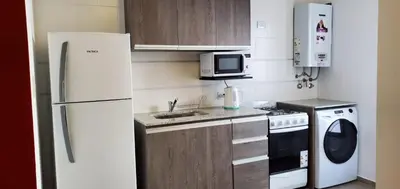 a kitchen with a white refrigerator and a microwave at Encantador departamento en General Paz in Cordoba