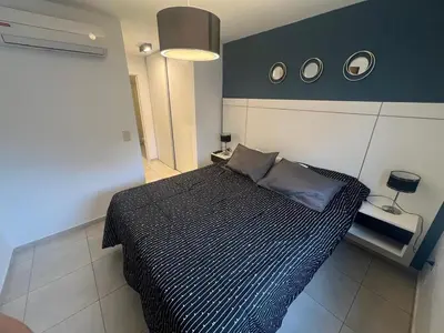 a bedroom with a black and white bed with two pillows at Encantador departamento en General Paz in Cordoba