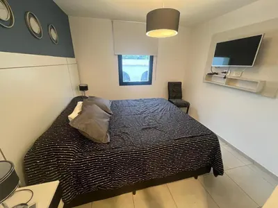 a bedroom with a bed with a black and white comforter at Encantador departamento en General Paz in Cordoba