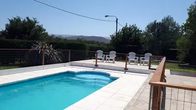 a swimming pool with chairs and a fence at Cabañas Finca del molino in Panaholma