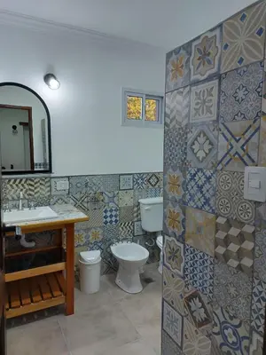 a bathroom with a toilet and a sink and a mirror at Cabañas Finca del molino in Panaholma