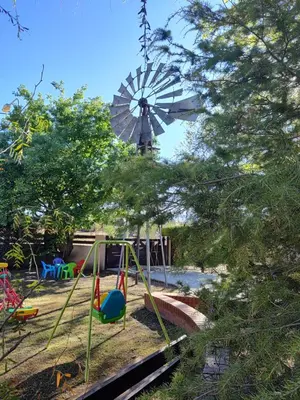 a playground with a windmill and a swing at Cabañas Finca del molino in Panaholma