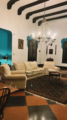 a living room with a couch and a chandelier at Estancia Saldañil in Villa Los Aromos