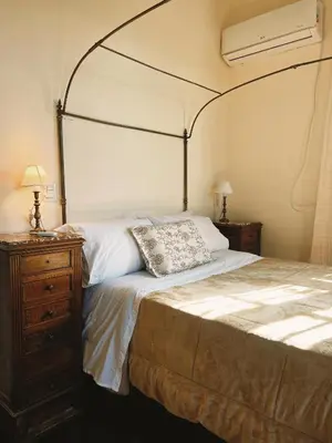 a bedroom with a canopy bed and a wooden dresser at Estancia Saldañil in Villa Los Aromos