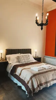 a bedroom with a large bed and a chandelier at Estancia Saldañil in Villa Los Aromos