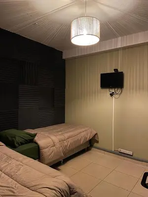 a room with two beds and a flat screen tv at Hostel Nueva cordoba Subte Uno in Cordoba