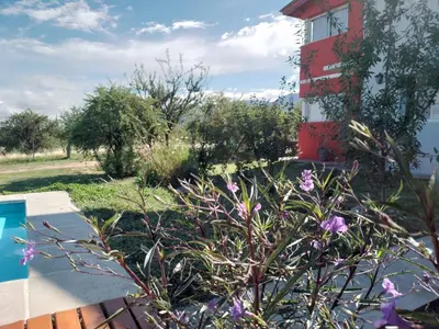 a garden with purple flowers in front of a building at Cabañas Merlina in Cortaderas