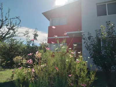 a garden in front of a building with flowers at Cabañas Merlina in Cortaderas