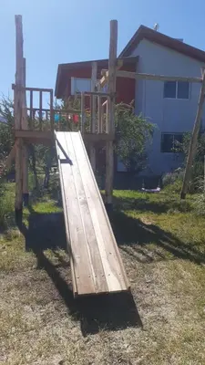 a wooden slide in the yard of a house at Cabañas Merlina in Cortaderas
