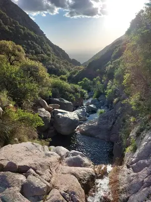 a river in a valley with rocks and trees at Cabañas Merlina in Cortaderas