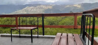 a bench on a porch with a view of mountains at Cabañas Merlina in Cortaderas