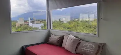 a window seat with a couch in front of a window at Cabañas Merlina in Cortaderas