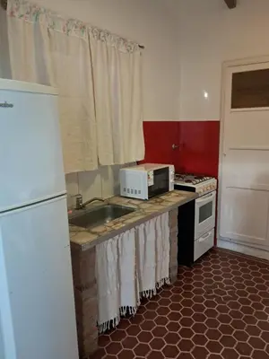 a kitchen with a sink and a microwave at La Casa de María Helenra in Alta Gracia