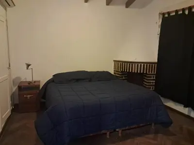 a bedroom with a bed with a blue blanket at La Casa de María Helenra in Alta Gracia