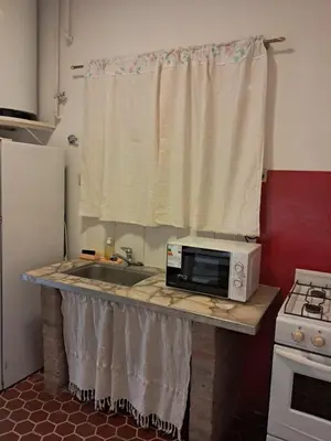 a kitchen counter with a microwave and a sink at La Casa de María Helenra in Alta Gracia