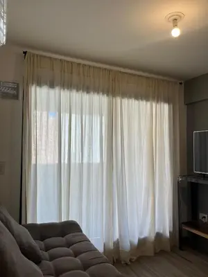 a living room with a large window with white curtains at DEPARTAMENTO TEMPORARIO UNICO CON SEGURIDAD 24 HS EN LA MEJOR ZONA NvA CORDOBA in Cordoba