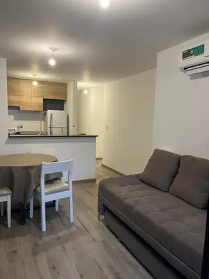 a living room with a couch and a table and a kitchen at DEPARTAMENTO TEMPORARIO UNICO CON SEGURIDAD 24 HS EN LA MEJOR ZONA NvA CORDOBA in Cordoba