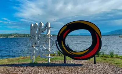 a largeulpture of a mirror on the side of a body of water at Duplex 1 Dormitorio Costa Azul in Villa Carlos Paz