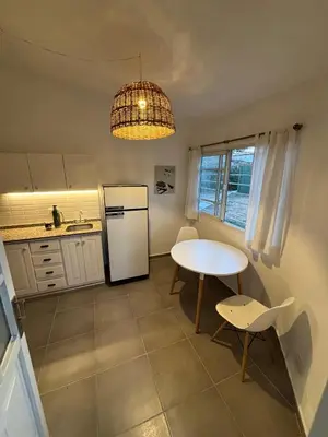 a kitchen with a white refrigerator and a table at Duplex 1 Dormitorio Costa Azul in Villa Carlos Paz