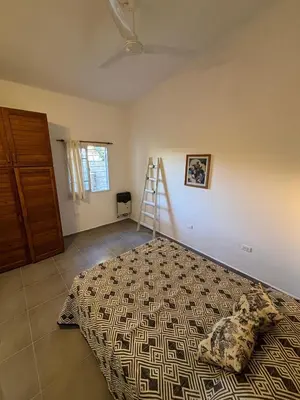 a bedroom with a bed and a ladder on the wall at Duplex 1 Dormitorio Costa Azul in Villa Carlos Paz