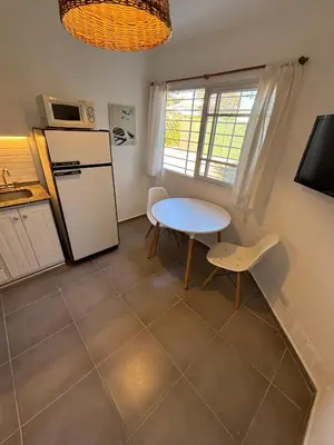 a kitchen with a table and a white refrigerator at Duplex 1 Dormitorio Costa Azul in Villa Carlos Paz