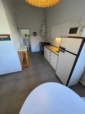 a kitchen with a refrigerator and a table in it at Duplex 1 Dormitorio Costa Azul in Villa Carlos Paz