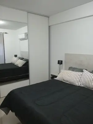 a bedroom with a black bed and a mirror at Depto Centrico Etoile 4 in Villa Carlos Paz
