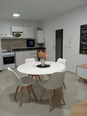 a kitchen with a white table and chairs in a room at Depto Centrico Etoile 4 in Villa Carlos Paz