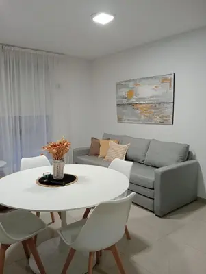 a living room with a white table and a couch at Depto Centrico Etoile 4 in Villa Carlos Paz