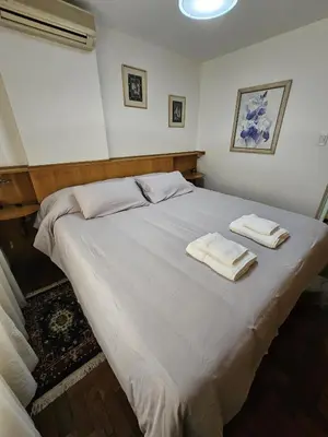 a bedroom with a large white bed with towels on it at Departamento Córdoba Semipiso frente a Patio Olmos in Cordoba