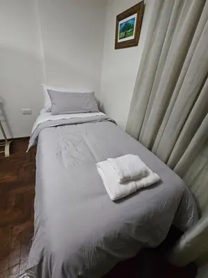 a bed with a white towel on top of it at Departamento Córdoba Semipiso frente a Patio Olmos in Cordoba