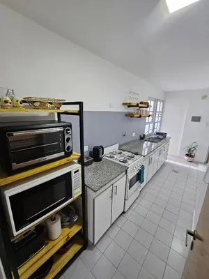 a kitchen with a microwave and a stove top oven at Departamento Córdoba Semipiso frente a Patio Olmos in Cordoba