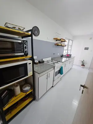 a kitchen with a stove and a microwave at Departamento Córdoba Semipiso frente a Patio Olmos in Cordoba