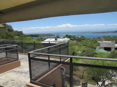 a balcony with a view of the water at Cabañas El Mirador in Embalse