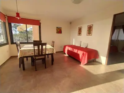a bedroom with a table and a bed and a table and chairs at Cabañas El Mirador in Embalse