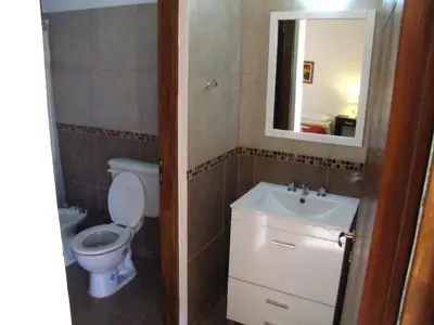 a bathroom with a toilet and a sink and a mirror at Cabañas El Mirador in Embalse