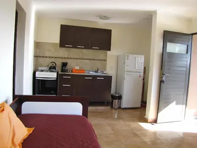 a kitchen with brown cabinets and a white refrigerator at Cabañas El Mirador in Embalse