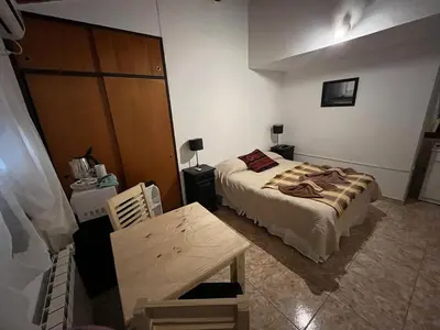 a bedroom with a bed and a wooden cabinet at Complejo El Viejo Nogal in Villa General Belgrano