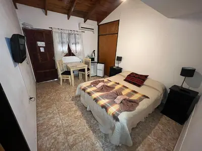 a bedroom with a bed and a desk and a television at Complejo El Viejo Nogal in Villa General Belgrano