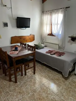 a bedroom with a table and a bed and a television at Complejo El Viejo Nogal in Villa General Belgrano