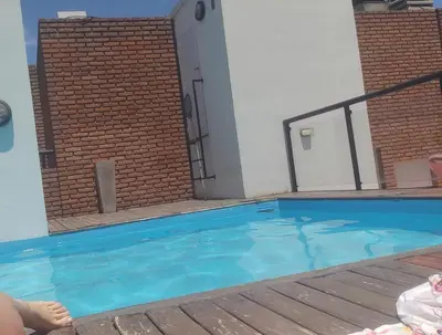 a swimming pool with blue water in front of a building at dpto próximo patio olmos pileta in Cordoba