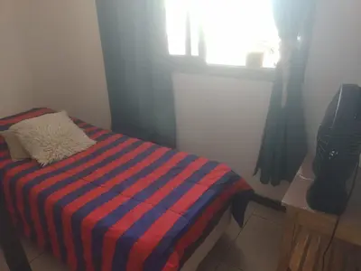 a bedroom with a bed with a striped blanket at dpto próximo patio olmos pileta in Cordoba