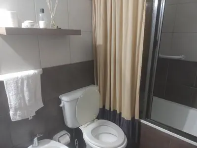 a bathroom with a toilet and a shower at dpto próximo patio olmos pileta in Cordoba