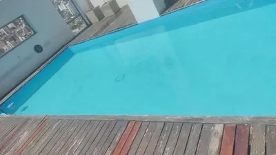 a large blue swimming pool on a wooden deck at dpto próximo patio olmos pileta in Cordoba
