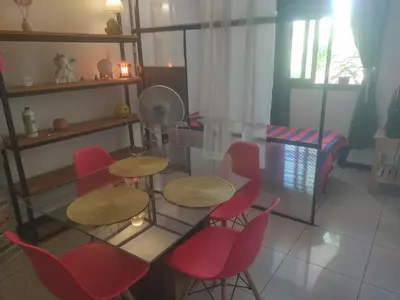 a room with two tables and red chairs and a bed at dpto próximo patio olmos pileta in Cordoba